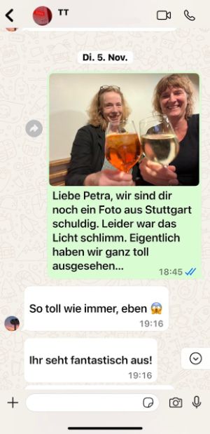 Screenshot of a chat with a photo of Sabine Leucht and Katrin Ullmann toasting with white wine and Aperol Spritz