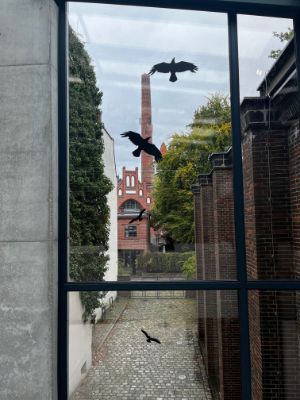 View through a window of a brick building with a tall chimney