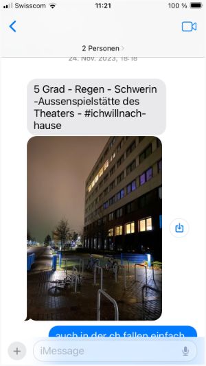 Screenshot of a chat with a picture of a building that looks like an office block in the dark and rain in Schwerin