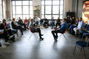 Eine Gruppe vom Menschen diskutiert in einem Sesselkreis.