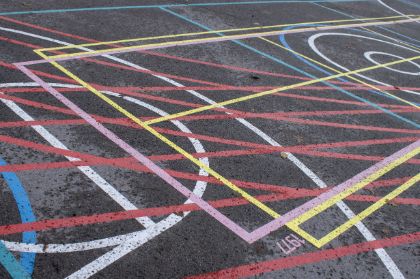 Ein Muster aus farbigen Linien und Kreisen auf Asphalt