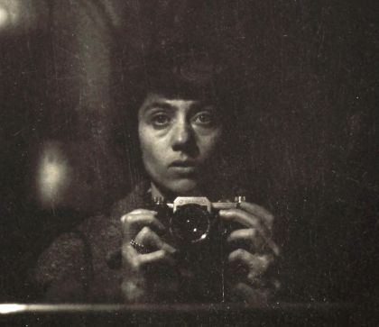 Diane Arbus fotografiert sich selbst vor einem Spiegel.